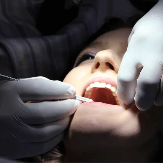 imagem de um dentista analisando a boca da paciente